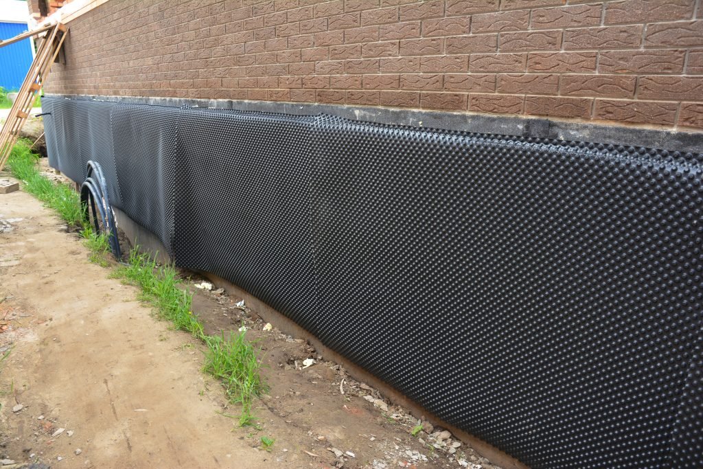 Exterior waterproofing of building foundation with a waterproofi