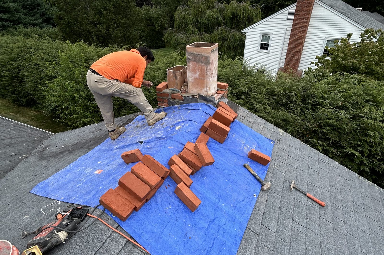 All State Masonry crew rebuilding a brick chimney on a roof in Arlington VA
